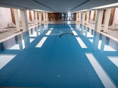 a large indoor swimming pool with blue water at Aqua Paradise Resort & Aqua Park in Nesebar