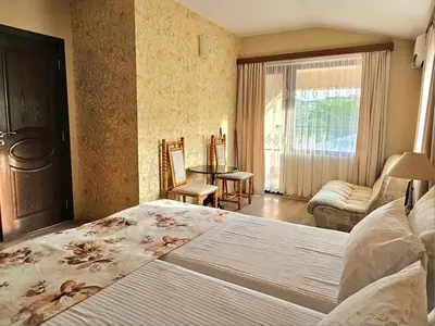 a bedroom with a large bed and a living room at Villa Magnolia in Sozopol