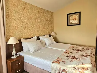 a hotel room with a bed and a table with a lamp at Villa Magnolia in Sozopol