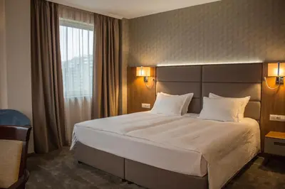 a hotel room with a large bed with white pillows at Hotel Golden Tulip Varna in Varna City