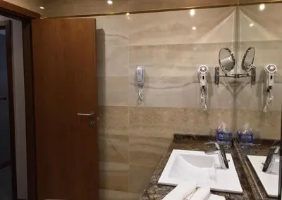 a bathroom with two sinks and a mirror at Hotel Golden Tulip Varna in Varna City
