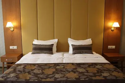 a bedroom with a large bed with two pillows at Hotel Golden Tulip Varna in Varna City