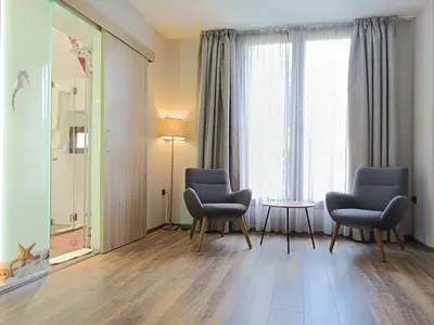 a room with two chairs and a table and a window at Hugo Hotel in Varna City