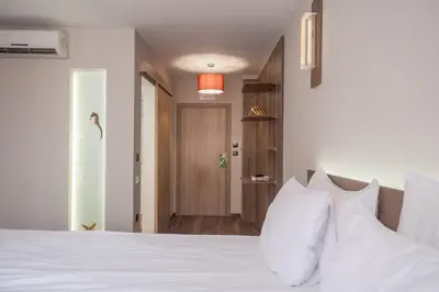 a bedroom with a white bed with white pillows at Hugo Hotel in Varna City