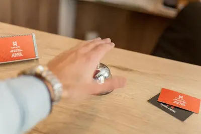 a person sitting at a table with their hand on a mouse at Hugo Hotel in Varna City