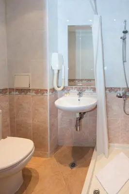 a bathroom with a sink and a toilet and a mirror at Boutique Splendid Hotel in Varna City