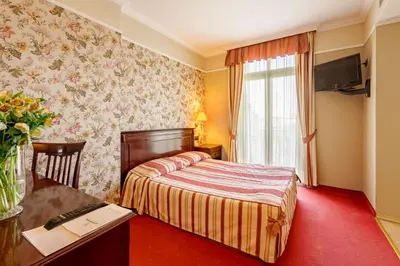 a hotel room with a bed and a desk and a window at Boutique Splendid Hotel in Varna City