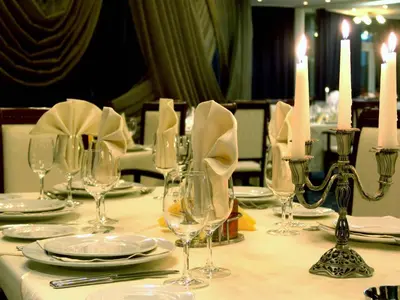 a table with glasses and plates and candles on it at Mirage Hotel in Burgas City