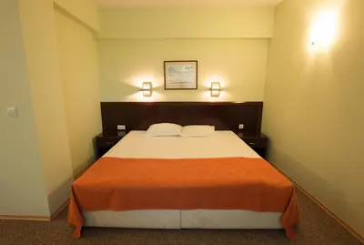 a bedroom with a large bed with two pillows at Hotel Divesta - self check in in Varna City
