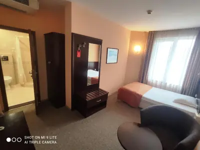 a hotel room with a bed and a mirror at Hotel Divesta - self check in in Varna City