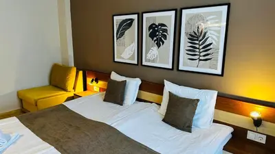 a bedroom with a large bed with three pictures on the wall at Queen Nelly in Primorsko