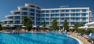 a hotel with a swimming pool in front of a building at Queen Nelly in Primorsko