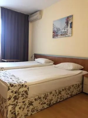 two twin beds in a hotel room with avertisement for at Hotel Atol in Sunny Beach