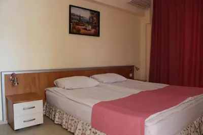 a bedroom with a large bed with a red curtain at Hotel Atol in Sunny Beach