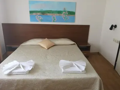 a bed with two white towels on top of it at Family Hotel Verona in Sozopol