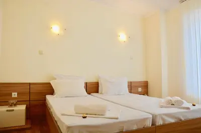 a bedroom with two beds with white sheets and towels at Rainbow 1 Holiday Complex in Sunny Beach
