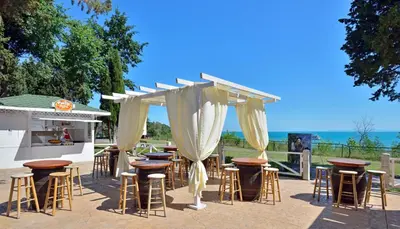 a group of tables and stools in front of a bar at Sol Nessebar Bay All Inclusive in Nesebar