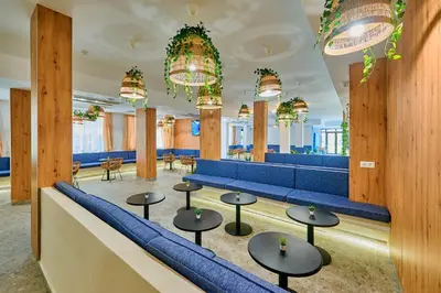a waiting room with blue seats and tables at Casablanca Hotel - All Inclusive in Obzor