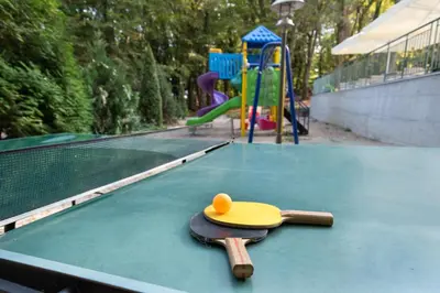 a hat sitting on top of a table next to a playground at Ariana Hotel in Kiten