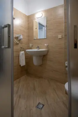 a bathroom with a sink and a mirror at Ariana Hotel in Kiten