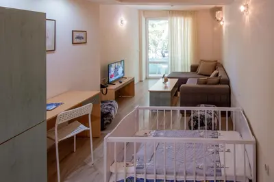 a living room with a crib in the middle of a room at Ariana Hotel in Kiten