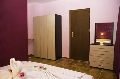 a bedroom with a bed with a dresser and a mirror at ,,Дироси'' in Sveti Vlas
