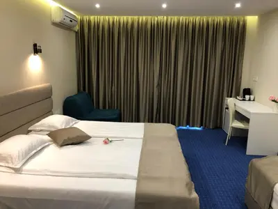 a hotel room with a bed and a desk at Family Hotel Avenue in Kiten