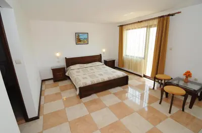 a bedroom with a bed and a table and chairs at More Family Hotel in Sozopol