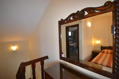 a mirror on the wall of a bedroom with a bed at More Family Hotel in Sozopol