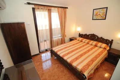 a bedroom with a bed and a large window at More Family Hotel in Sozopol