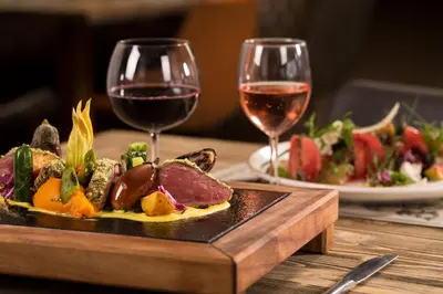 a plate of food and two glasses of wine at Obzor Beach Resort in Obzor