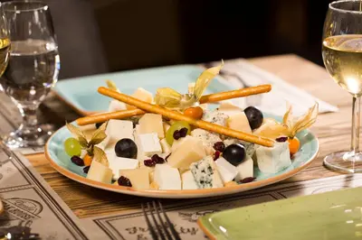 a plate of food with cheese and olives on a table at Obzor Beach Resort in Obzor