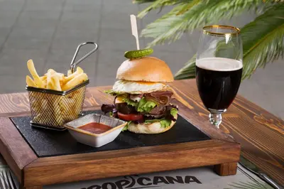a tray with a sandwich and fries and a glass of beer at Obzor Beach Resort in Obzor