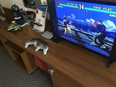 a television screen with two video game controllers on a desk at Hotel Burgas in Burgas City