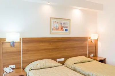 a hotel room with two beds and two lamps at Hotel Burgas in Burgas City