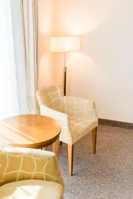 a living room with two chairs and a table at Hotel Burgas in Burgas City