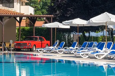 a group of chairs and umbrellas next to a swimming pool at Melia Sunny Beach All Inclusive in Sunny Beach