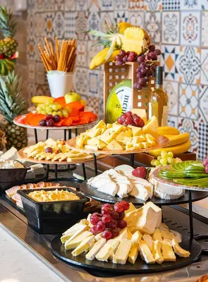 a buffet filled with different types of cheese and fruit at Melia Sunny Beach All Inclusive in Sunny Beach