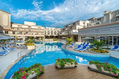 a resort with a pool and chairs and buildings at Martinez Hotel All Inclusive in Sozopol