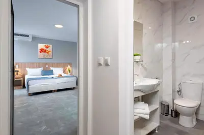a bathroom with a bedroom with a bed and a sink at Martinez Hotel All Inclusive in Sozopol
