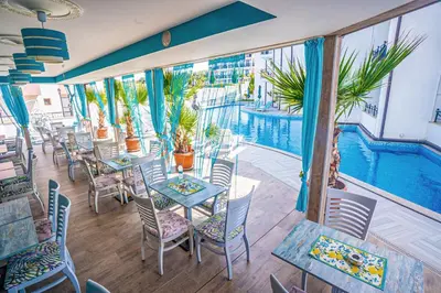 a restaurant with tables and chairs and a swimming pool at Royal Calisto Hotel in Sozopol