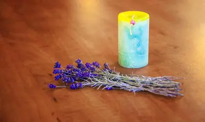 a candle and purple flowers on a wooden table at Plaza Hotel in Varna City