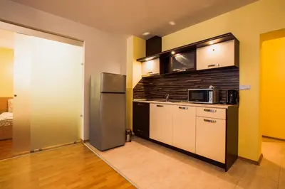 a kitchen with a refrigerator and a microwave at Aparthotel Marina Holiday Club - All Inclusive & Free Parking in Pomorie