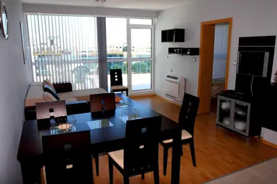 a living room with a table and chairs and a dining room at Aparthotel Marina Holiday Club - All Inclusive & Free Parking in Pomorie