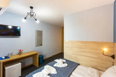 a hotel room with a bed and a desk at Family Hotel Jemelly in Obzor