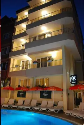 a building with chairs and umbrellas next to a pool at Italia Hotel in Nesebar