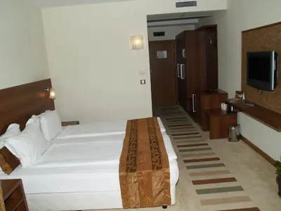 a hotel room with a bed and a television at Laguna Beach Resort & Spa in Sozopol
