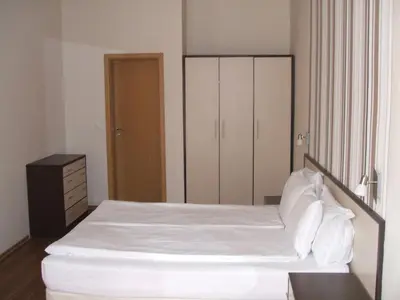 a bedroom with a white bed and a cabinet at Laguna Beach Resort & Spa in Sozopol