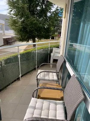 a porch with two chairs and a bench on a balcony at Apartament Ivanovi A119 in Burgas City