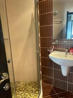 a bathroom with a sink and a glass shower at Apartament Ivanovi A119 in Burgas City